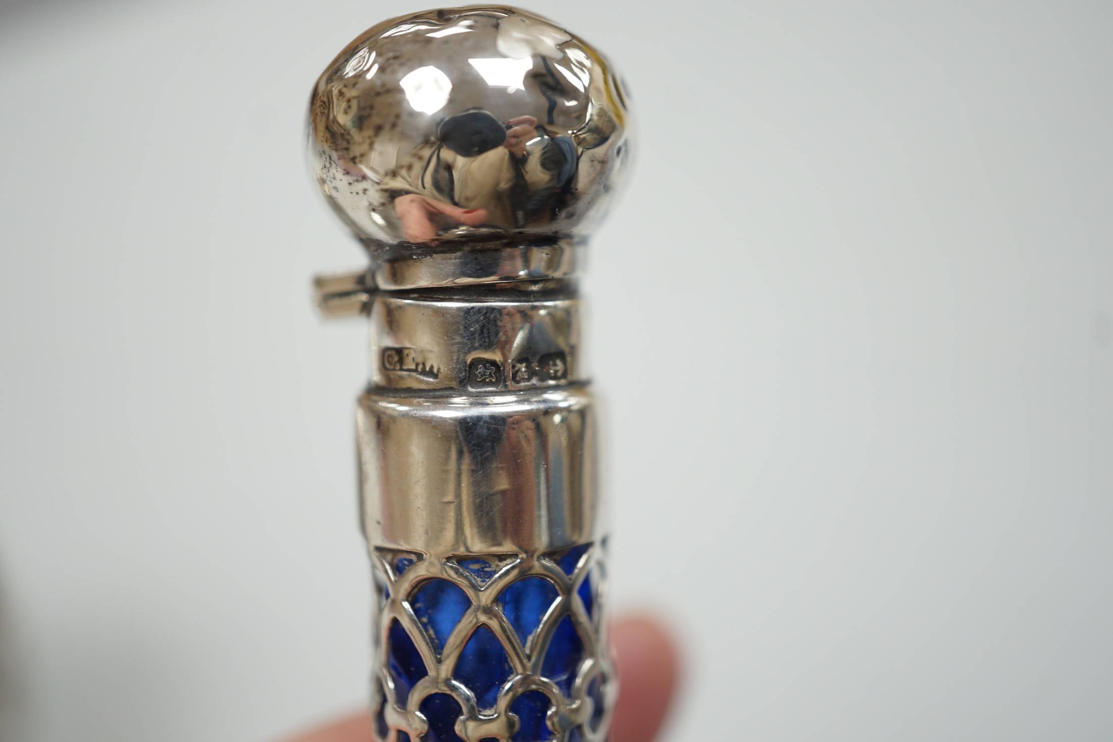 A late Victorian aesthetic engraved silver cylindrical scent bottle, by Sampson Mordan, London, 1881, 54mm, two other mounted glass scent bottles and a similar silver mounted demi tasse cup.